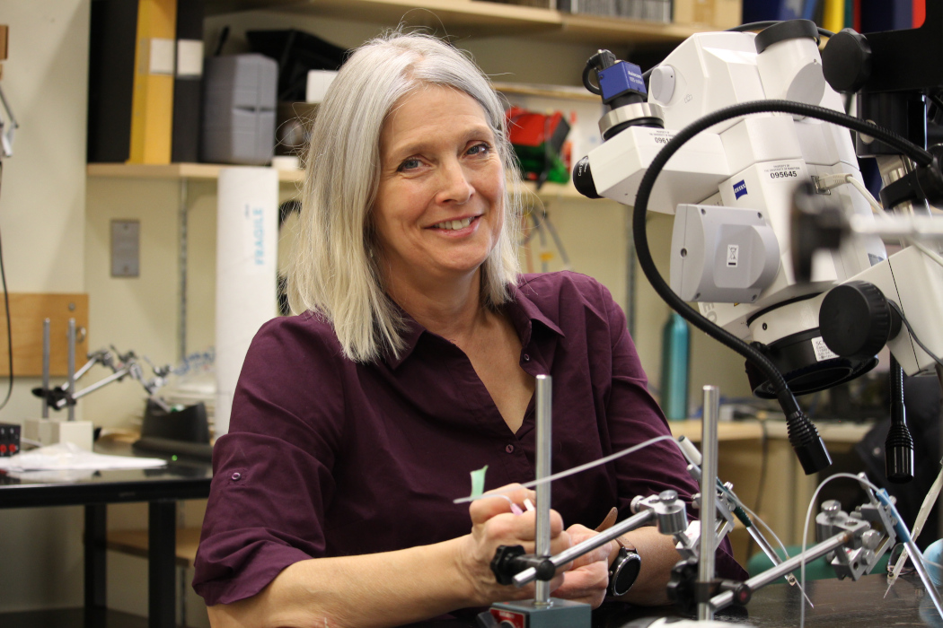 Dr. Kristine Cowley in her lab. A large piece of scientific equipment is in the foreground.