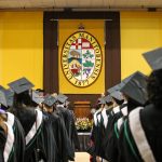 group of graduates photographed from behind featuring the university of manitoba crest