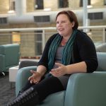 Lisa Engel talks while sitting on a chair at Banntyne Campus.