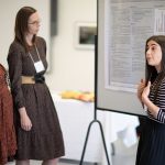 woman presenting in front of a poster