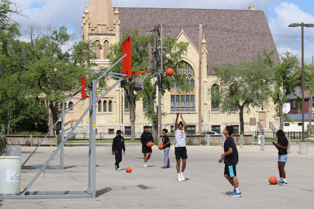 Six basketball players shoot hoops on two baskets.