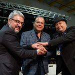 three men shake hands