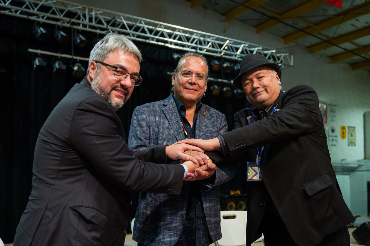 three men shake hands