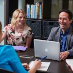 Staff and faculty collaborate around a table at the University of Manitoba.
