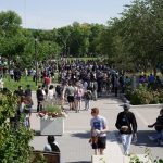 wide shot of um fort garry campus during orientation, many students on curry pedway picutred on sunny day.