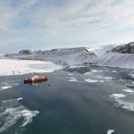 A ship set in ice water amid the surrounding Arctic environment.