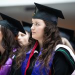 Kaylene Normand in her cap and gown, wearing an Indigenous sash, at convocation.