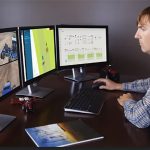 A person monitors tractors in a field