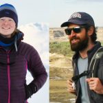 A woman in snow gear is standing to the left; a man in outdoor expedition gear stands to the right.