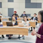 an instructor gives a lecture to business students in a classroom