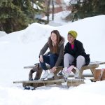 Students smile as they lace their skates on a winter day