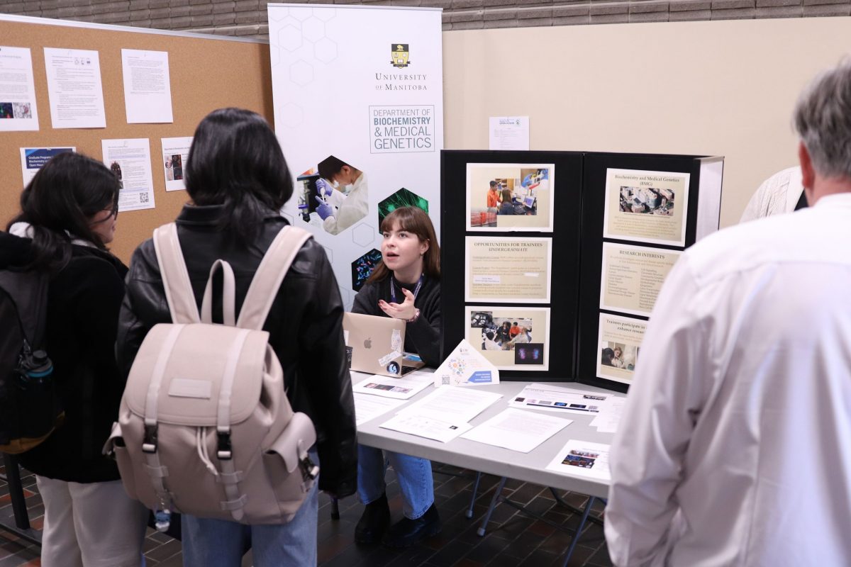 students are listening to a women speaking at the biochemistry and medical genetics information booth