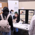 students are listening to a women speaking at the biochemistry and medical genetics information booth