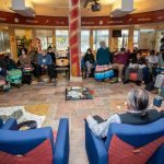 A group of of people sitting in chairs in a circle.