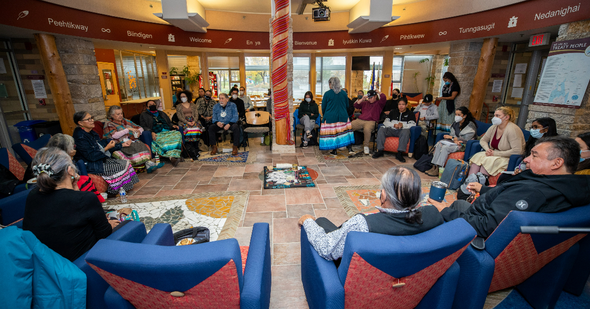 A group of of people sitting in chairs in a circle.
