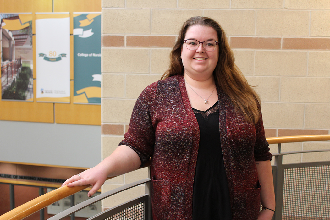 Michaela Bourque stands in the atrium of the College of Nursing's Helen Glass building on Fort Garry campus.