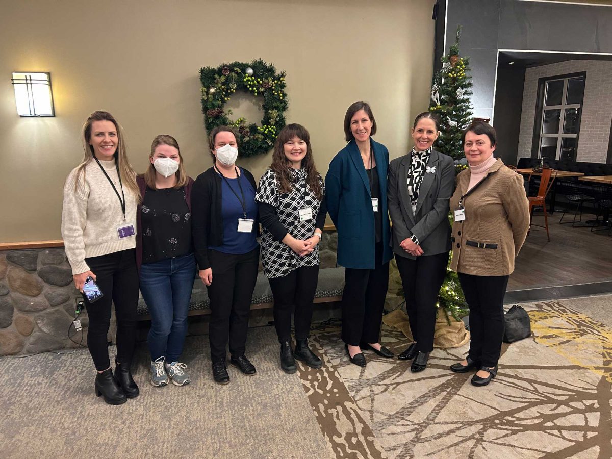 Seven people standing together at a conference