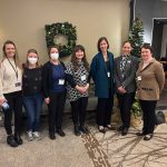 Seven people standing together at a conference