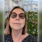 Self-photo of Carla Zelmer with plants in the background