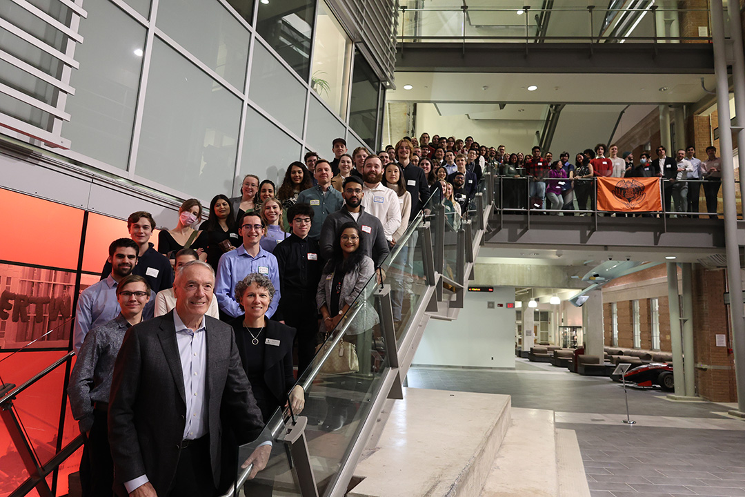 Dr. Gerry Price stands on stairs with hundreds of scholarship winners