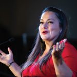Dr. Mandy Buss gestures while speaking at the 50th-anniversary gala of the department of family medicine.