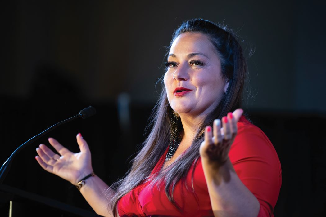 Dr. Mandy Buss gestures while speaking at the 50th-anniversary gala of the department of family medicine.