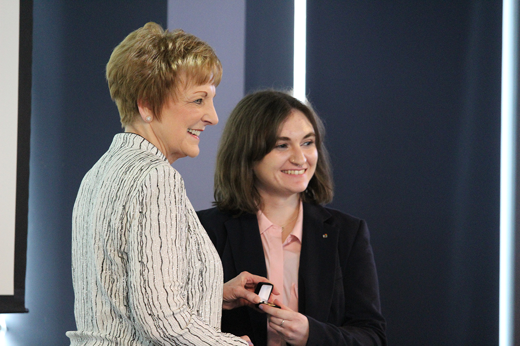 Zoie Hetletvedt receives her nursing pin from College of Nursing dean Dr. Netha Dyck.