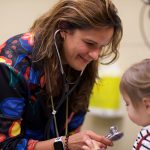 Metis physician examines a little girl