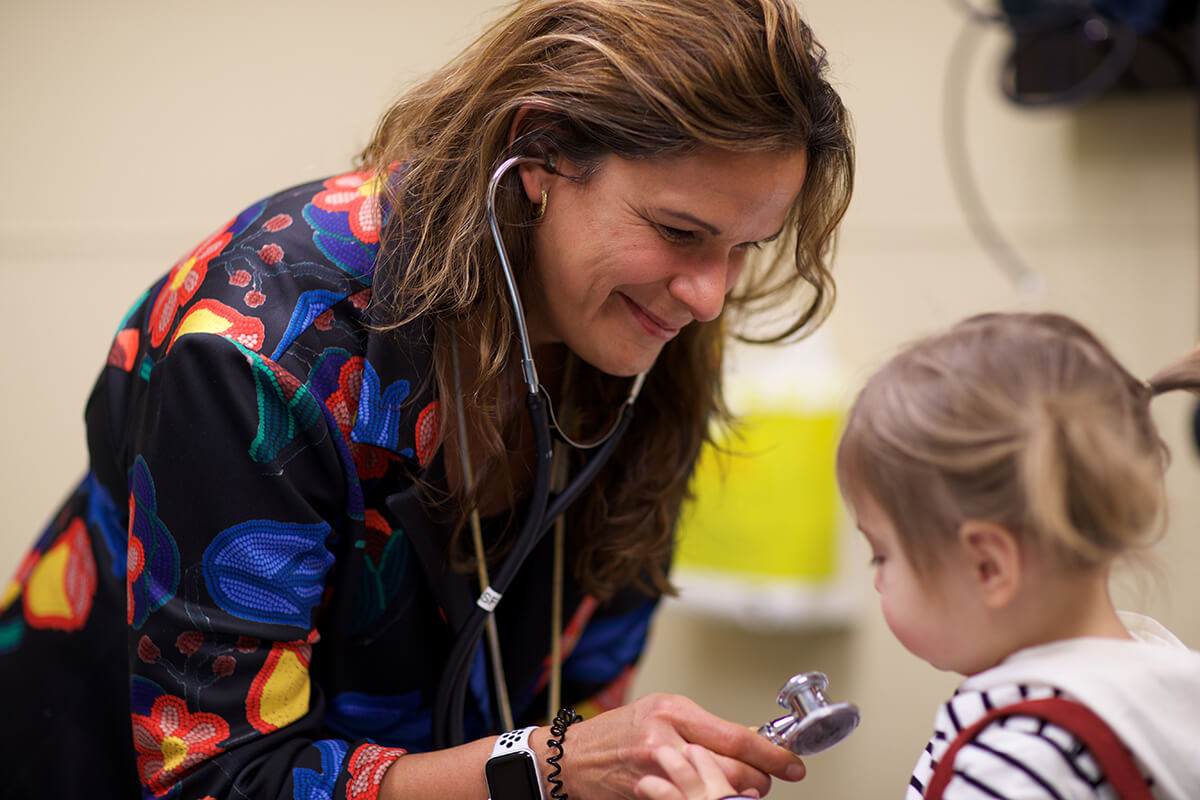 Metis physician examines a little girl