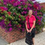 An image of Julie Mikuska standing in front of flowers.