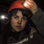 A women stares into camera wearing an orange hard hat