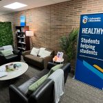 Healthy U Office with couches, plants and banner.