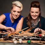 Tori Sparks and Catherine Wood look at a pile of mallets and clarinets.