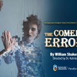 Pixelated woman with heavy makeup, spiky short hair and wearing a sparkly jumpsuit holding out her hand to her own reflection.