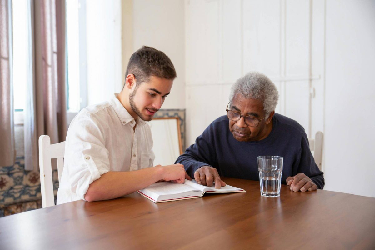 young adult and older adult reading together