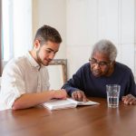 young adult and older adult reading together