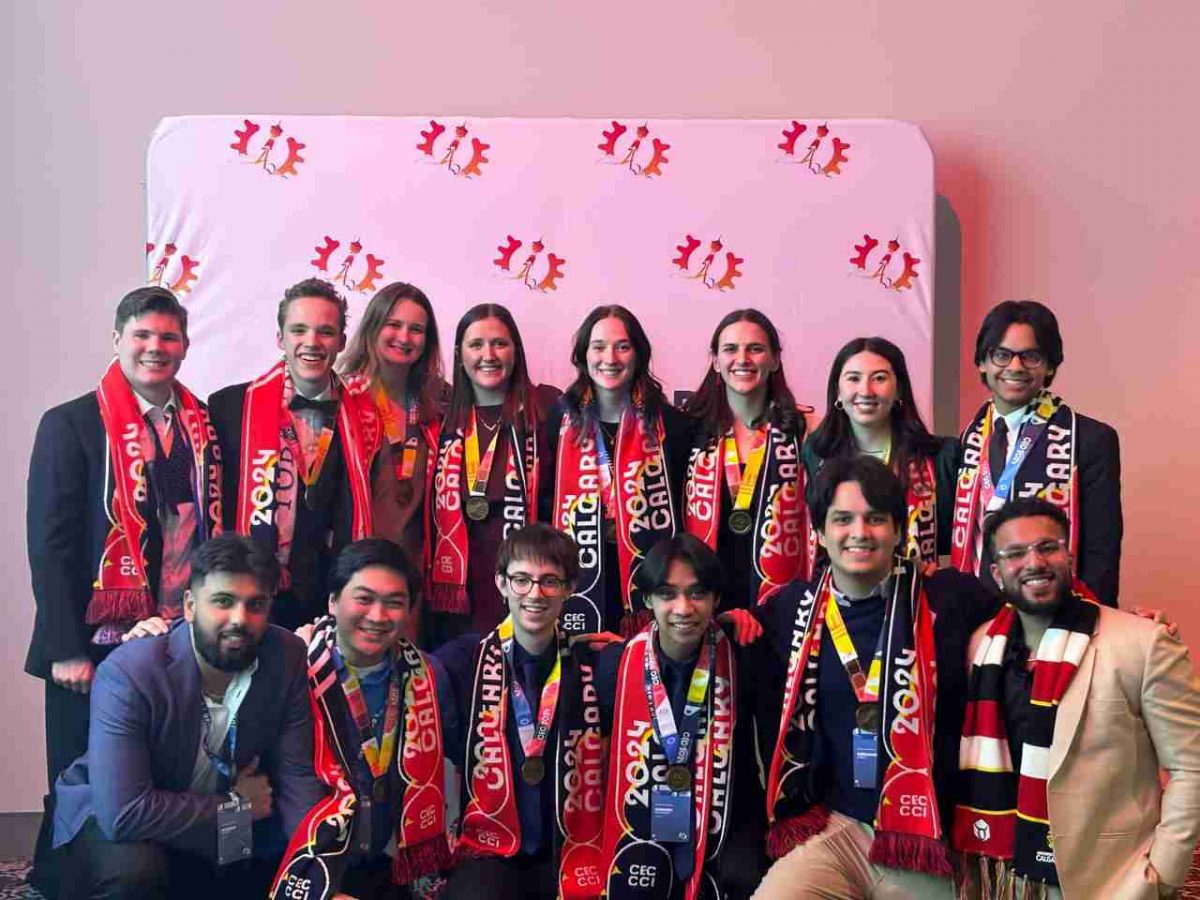 Group of UM students posing in front of backdrop