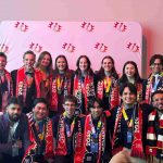 Group of UM students posing in front of backdrop