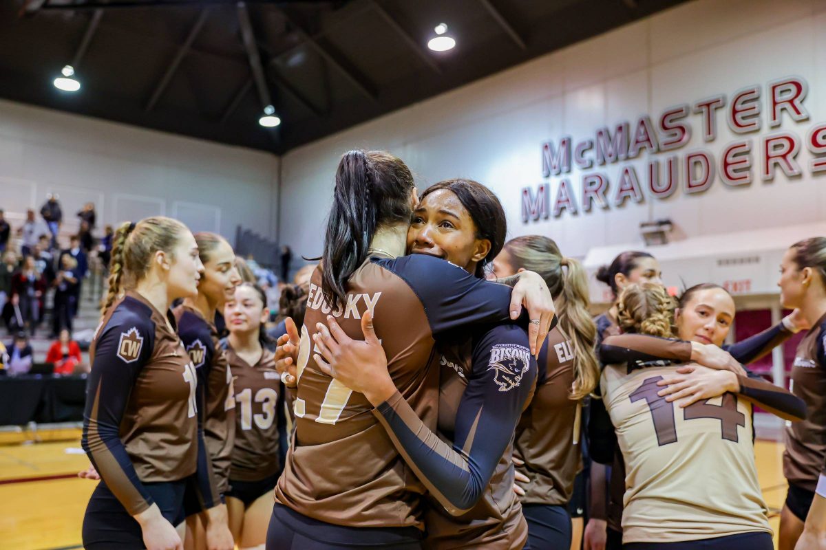 Bisons women's volleyball athletes hug after winning a bronze medal at the 2024 U Sports Championship