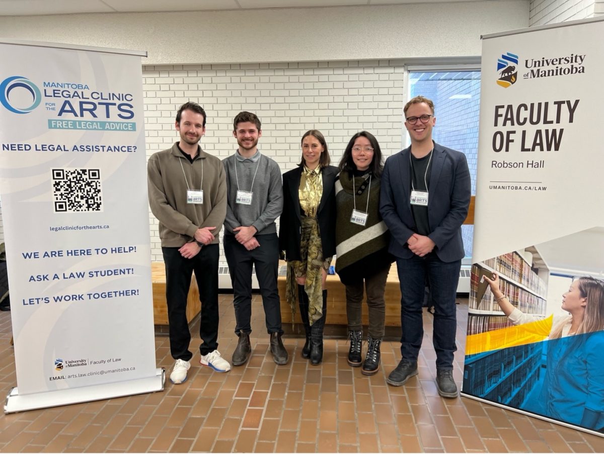 Law students stand between two roll-up banners Left to right: Scott Groot (3L), Austin Sutherland (3L), Gabrielle Swan (The Pas Arts Council), Kassandra Taverner (2L), and Stephan Possin (3L)