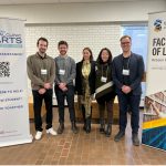Law students stand between two roll-up banners Left to right: Scott Groot (3L), Austin Sutherland (3L), Gabrielle Swan (The Pas Arts Council), Kassandra Taverner (2L), and Stephan Possin (3L)