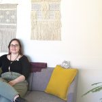 Sharlaine Glowatsky (she/they), the SVRC’s confidential intake & triage specialist on a couch in the Sexual Violence Resource Centre