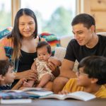 A family sits together on a sofa.