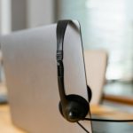 Photo of a computer and black headset with mouthpiece.