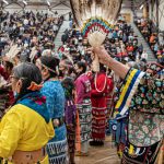 A group of pow wow dancers in colourful regalia.