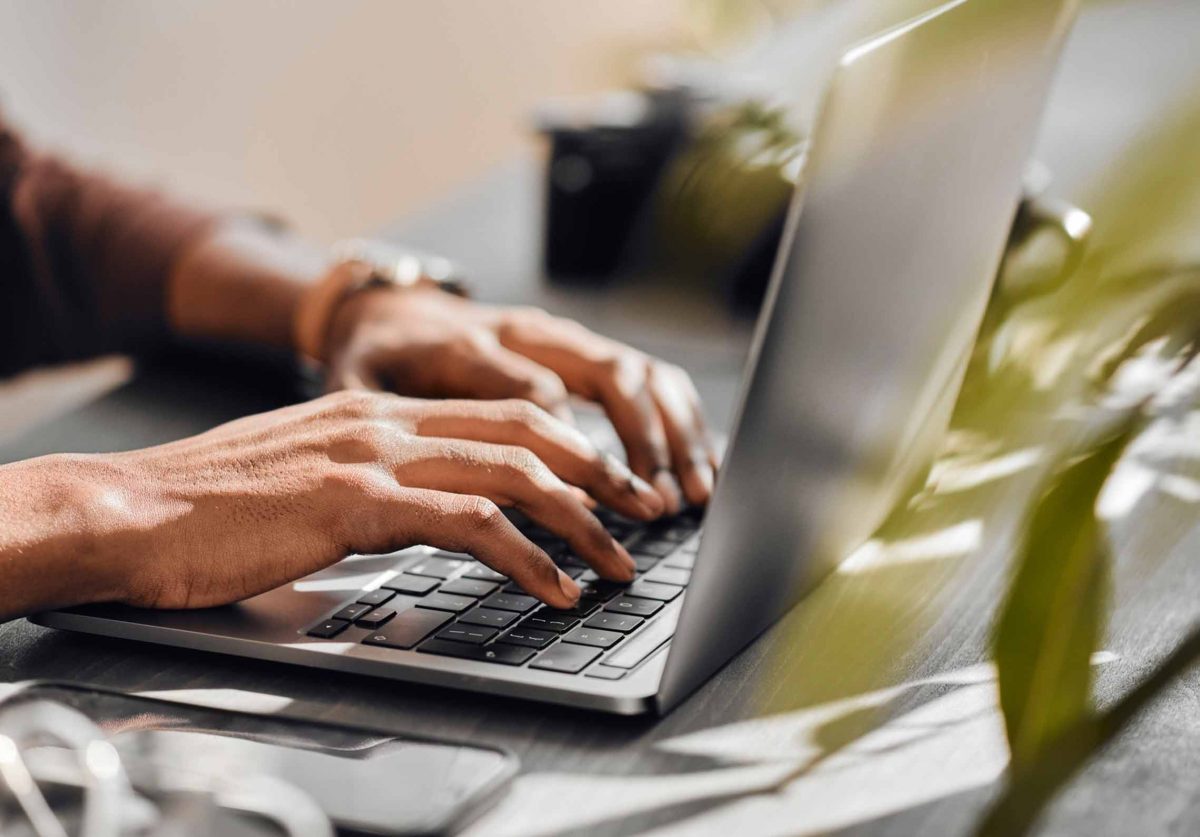 Hands typing at a desktop computer