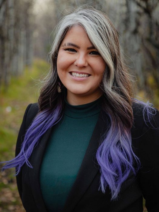 Jayelle-Friesen-Enns standing outdoors and smiling at the camera