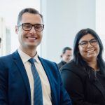 Photo of students smiling in a room, wearing suits. This was from the cover of the Desautels Centre 2024 Impact Report. Photo by 47 Filmworks.
