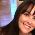 woman with black hair smiling to the camera