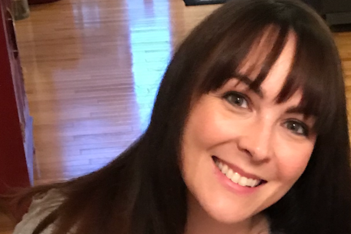 woman with black hair smiling to the camera